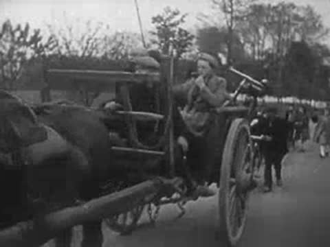 Horse-drawn carts carrying refugee belongings along a rural road.