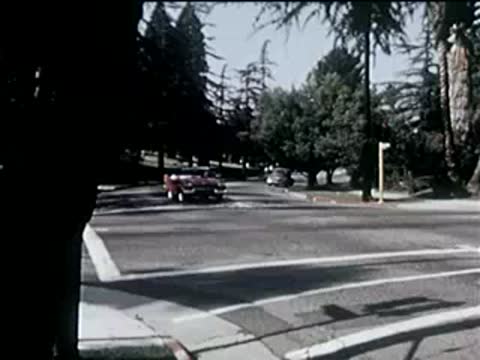 View from a car turning a corner at an intersection on a sunny day.