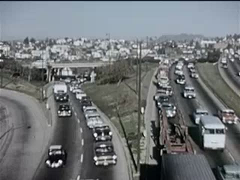 heavy traffic moving along a busy multi-lane highway, 1950s