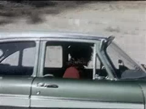 Side view of a woman sitting in the passenger seat of a car.