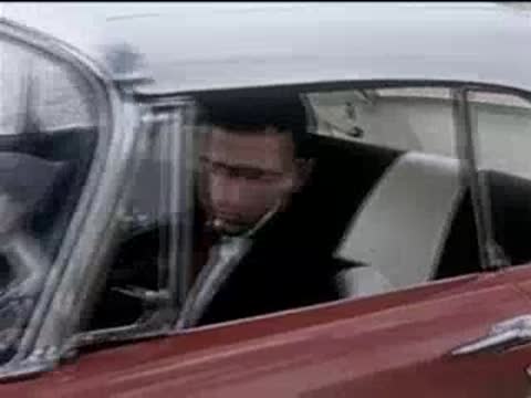 Driver in a red convertible looking concerned and frustrated while seated inside.