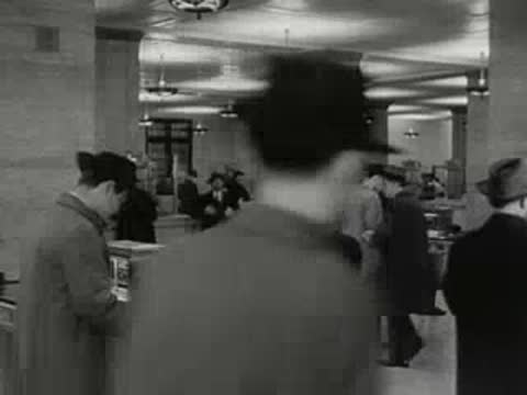 Customers standing at service counters inside a large bank.