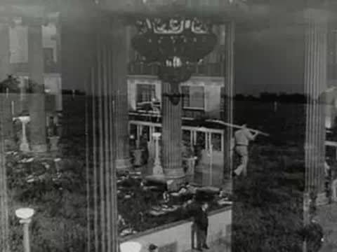 Transition from a bank interior to surveyors working in a field.