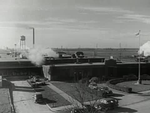 Exterior view of an industrial facility, then a man drinking coffee.
