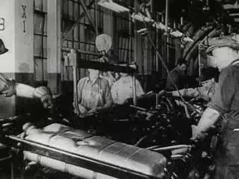 Workers in a manufacturing plant operating heavy machinery.