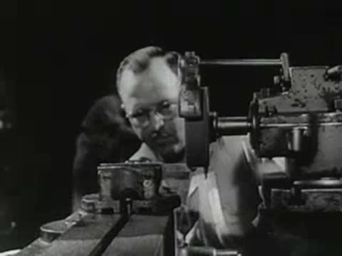 Machinist working on a lathe with sparks flying off the metal.