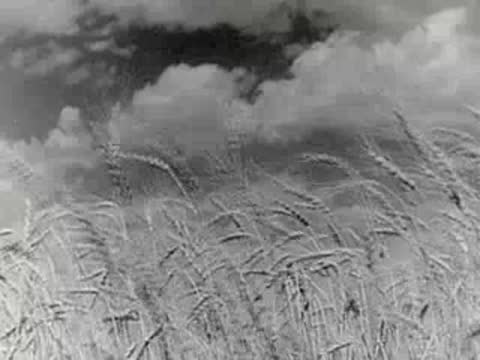 Transition from a machinist at work to a farmer walking in wheat.