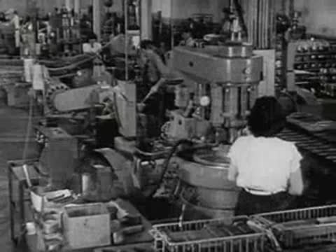 Worker operating machinery on an active industrial assembly line.