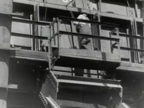 Industrial equipment unloads bulk material from a cargo vessel.