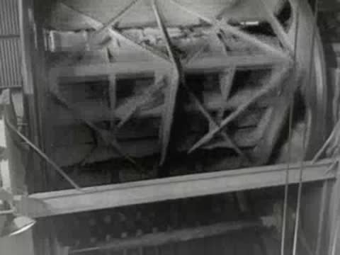 Rocks travel on an industrial conveyor belt and processing equipment.