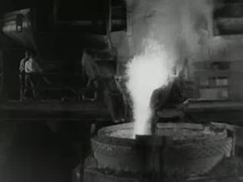 Molten metal pours from ladle into container with bright flames, 1950s.