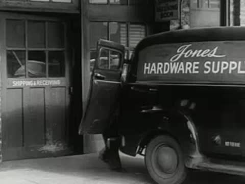 delivery driver stepping out of hardware supply van with box, 1950s