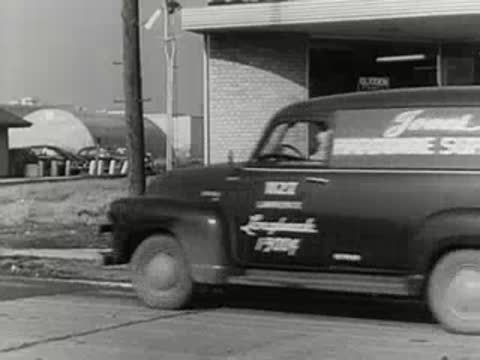 hardware supply delivery van parked in front of retail storefront, 1950s