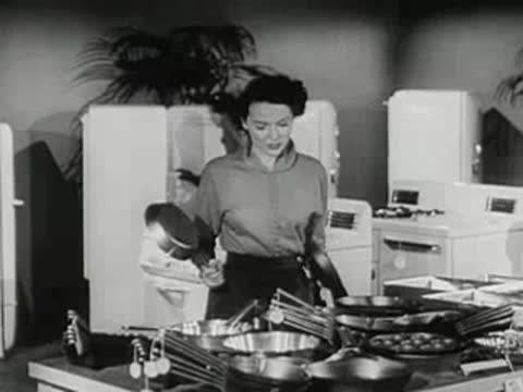 customer examining merchandise on display in kitchenware store, 1950s