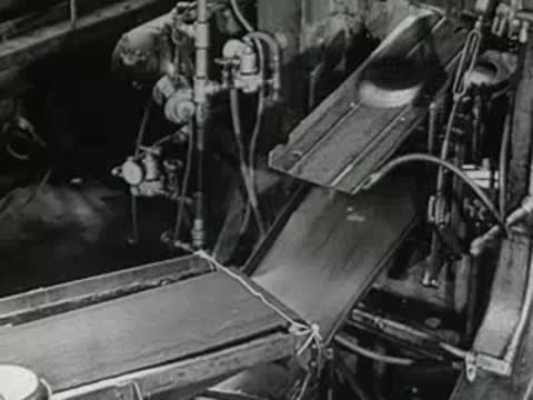 factory conveyor belt with metal pan lids, 1950s industrial facility