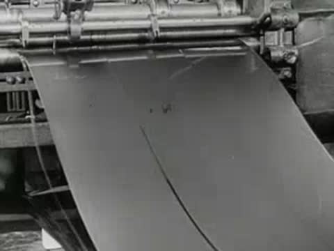 industrial sheet metal rolling through heavy machinery rollers, 1950s factory