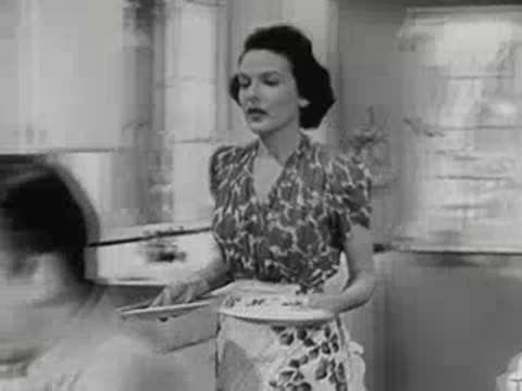 A woman serving cooked eggs and food to a man sitting at a dining table