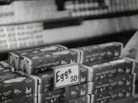 Stacked cartons of eggs on a grocery store shelf with a price tag