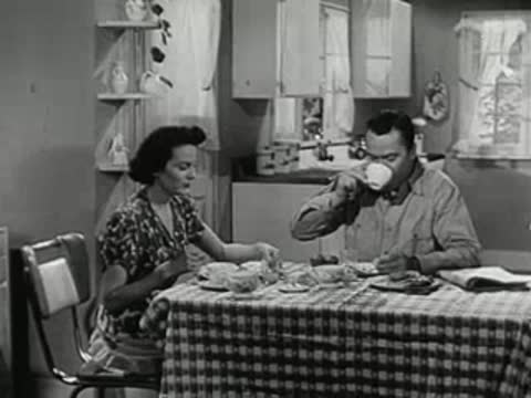 A man and woman sitting and eating breakfast together at a dining table