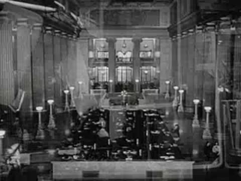 Interior of a large bank with high columns and teller windows.
