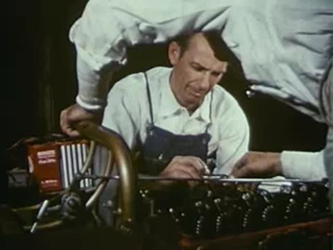 Mechanic adjusting engine components with tools.