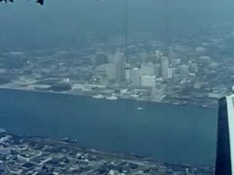 Aerial view from a plane flying over a city and river.