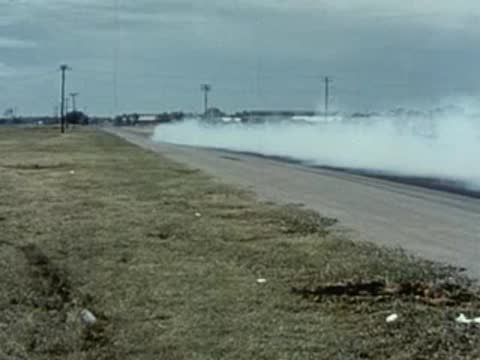 dragster doing burnout on track, vintage racing event