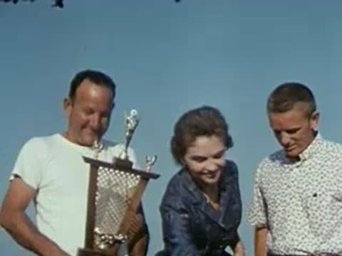 people holding large trophy, 1950s fashion