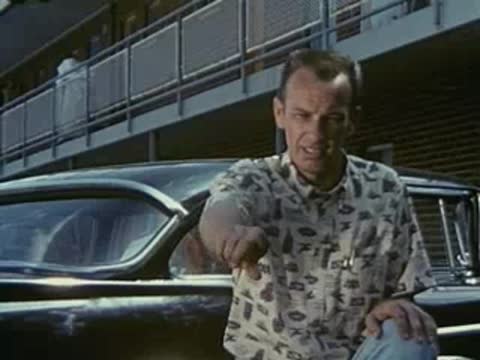 man talking outdoors near car, 1950s clothing