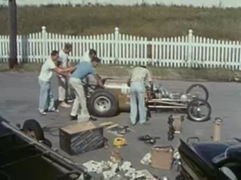 crew working on race car outdoors, pit stop area