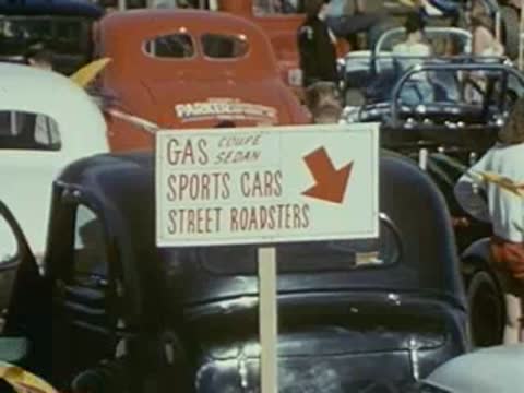 cars parked at vintage car show with signage, 1950s event