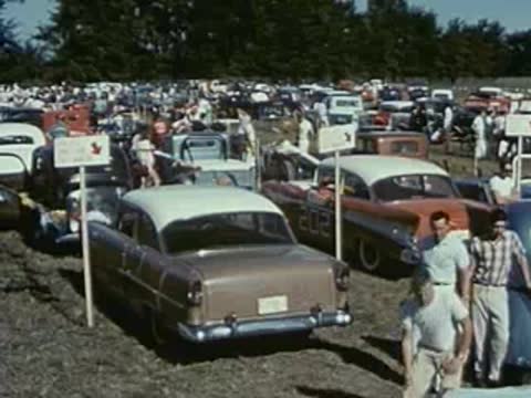 cars parked in lot at outdoor event, 1950s gathering