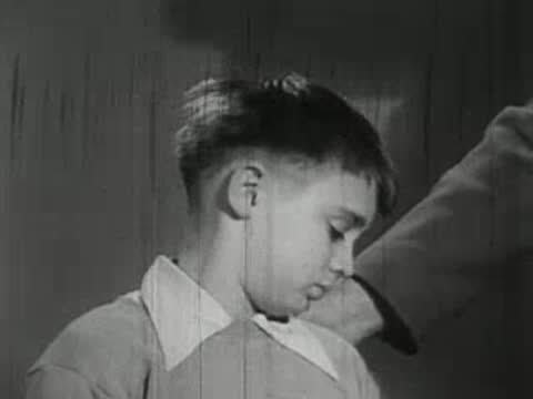 Close-up of sad young boy being comforted by adult hand.