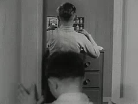 Young boy watching older boy play with chemistry set.