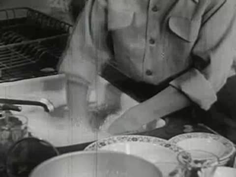 Hands washing dishes in a kitchen sink, vintage interior