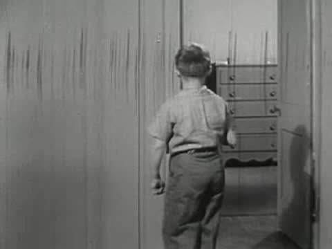 Boy opens dresser drawer in bedroom, vintage furniture