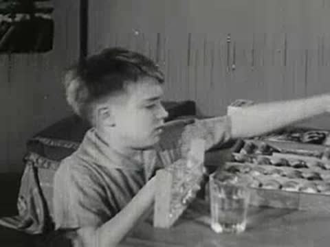Boy opens chemistry set box on table, vintage interior