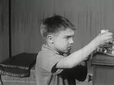 Boy taking test tube from rack in chemistry set