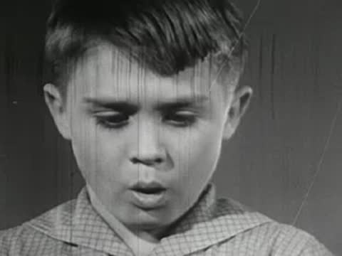 Broken glass on wooden floor and boy looking shocked