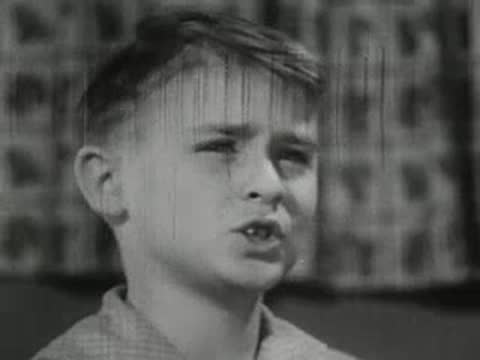 Boy making unhappy facial expression in kitchen interior
