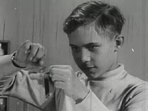 Close-up of boy mixing chemicals in test tubes.