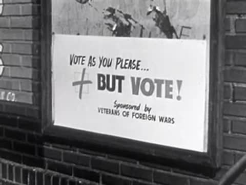 Sign reading "Vote as you please... But vote!" mounted on brick wall, VFW sponsored.