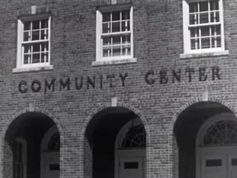 Exterior of a red brick building with the words COMMUNITY CENTER above arched doorways.