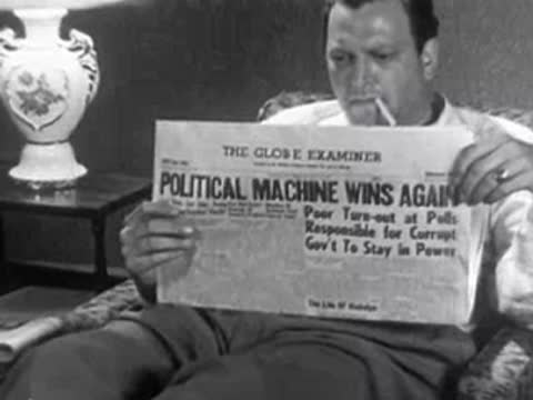 Man sitting and reading newspaper with headline "Political Machine Wins Again", 1950s.