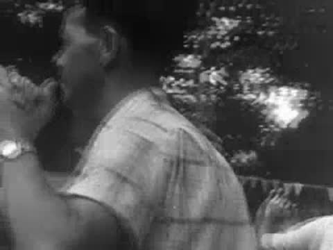 Close-up of a couple dancing outdoors, with the man wearing a service cap.