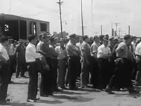 Group of men in work clothes standing in a line outdoors