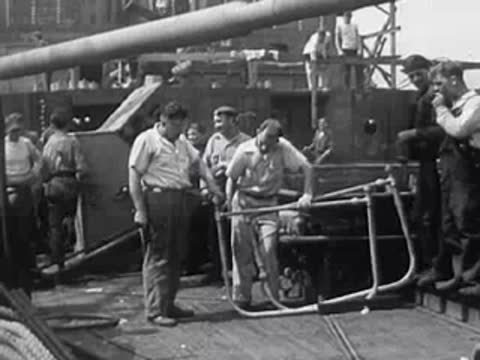 Men working on a large metal structure outdoors or industrial area.