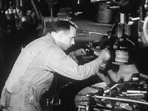 A worker operating industrial machinery in a factory or workshop.