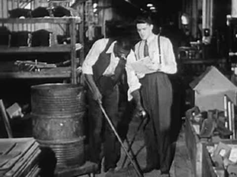 Several men gathered around industrial machinery and work areas.