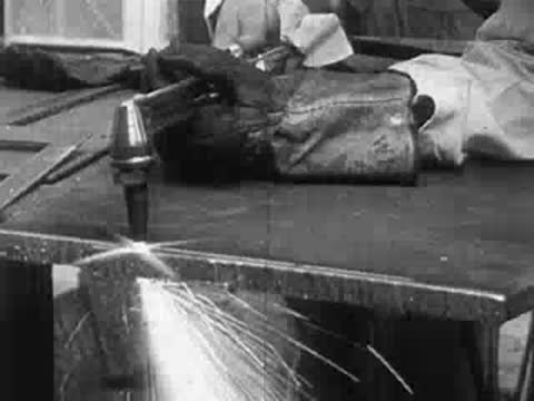 Close-up of workers using welding equipment, sparks flying.